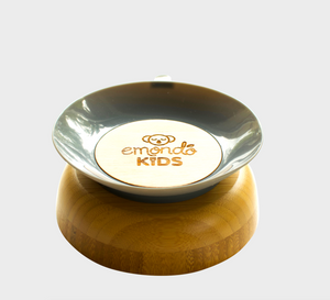 Bamboo bowl upside down with emondo kids logo on the bottom of it with grey rubber suction on the bottom of it