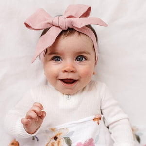 Baby girl wearing a dusty pink linen headband bow