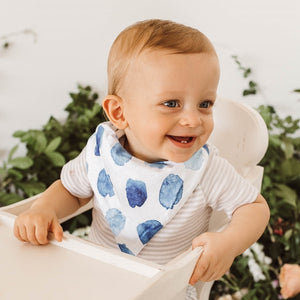 Little boy with a white bib and blue spots on it