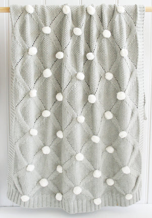 Grey knit baby blanket with ivory PomPoms