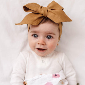 Baby girl wearing mustard coloured linen bow headband