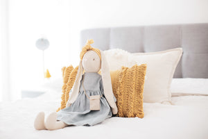 Alimrose Sofia Bunny in blue dress and mustard headband sitting on bed