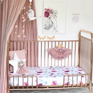 white and pink floral fitted cot sheet on gold cot 